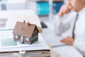 Mortgage advisor shaking hands with client across desk after loan discussion