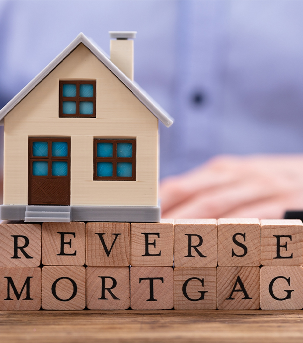 Smiling senior couple reviewing reverse mortgage documents at their kitchen table