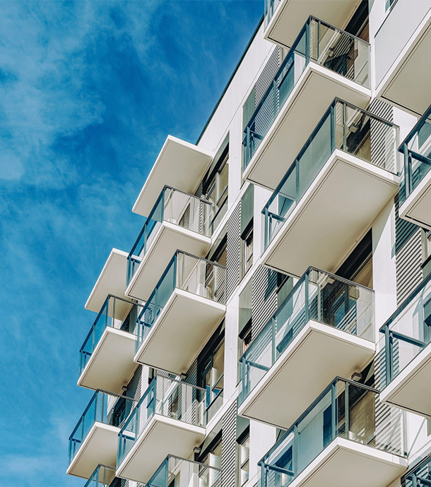 Row of modern condominium buildings with balconies under clear blue sky