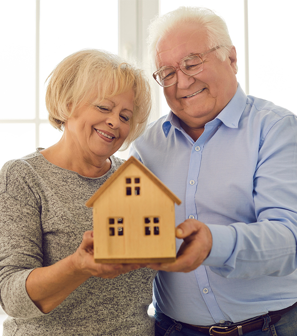 Senior woman sitting on living room sofa reading reverse mortgage brochure