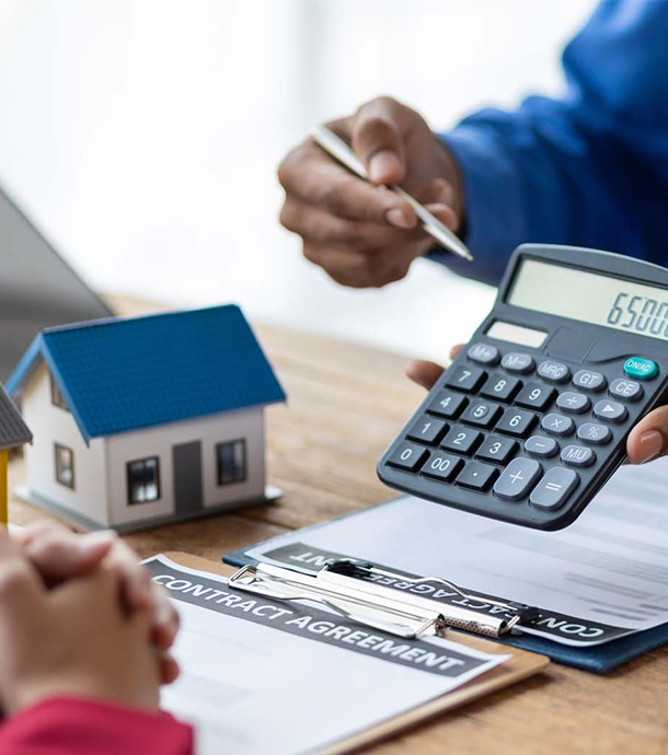 Homebuyer typing numbers into laptop while reviewing interest-only mortgage options